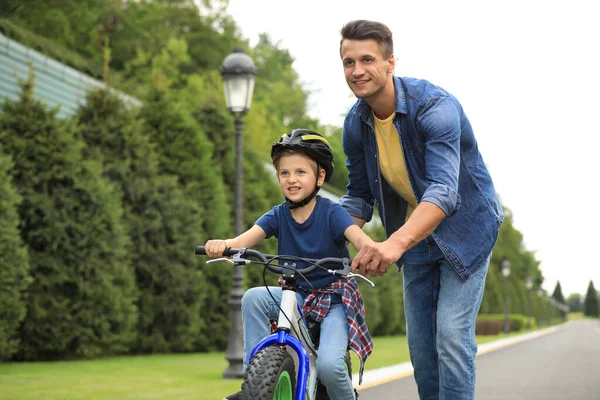 Tata uczy syna jeździć na rowerze na świeżym powietrzu — Zdjęcie stockowe