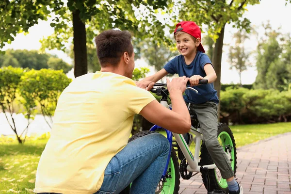 Tata uczy syna jeździć na rowerze na świeżym powietrzu — Zdjęcie stockowe