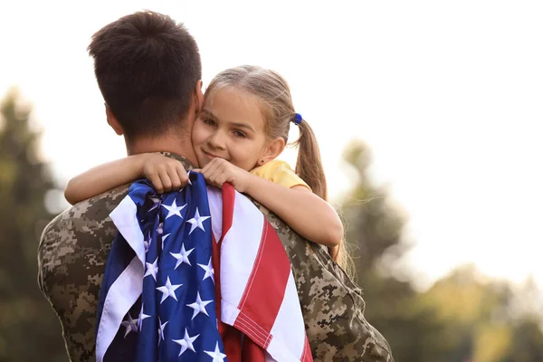 Padre en uniforme militar con bandera americana y su hija en Sunny Park — Foto de Stock