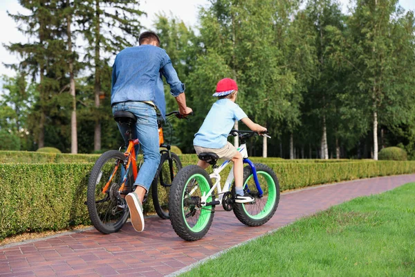 Tata i syn jeżdżący na nowoczesnych rowerach na świeżym powietrzu — Zdjęcie stockowe