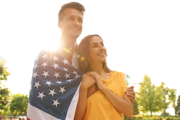 Hombre en uniforme militar con bandera americana y su esposa en Sunny Park — Foto de Stock