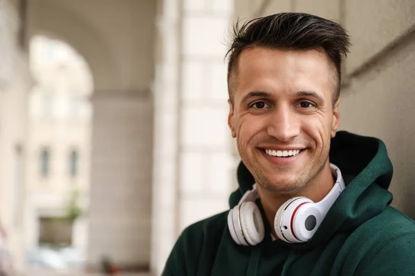 Retrato de jovem bonito com fones de ouvido ao ar livre. Espaço para texto — Fotografia de Stock