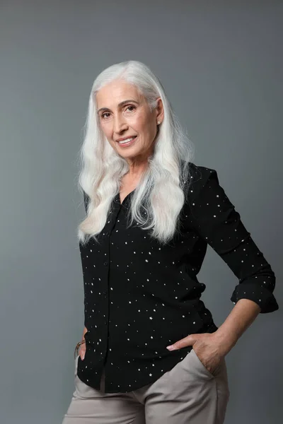 Porträtt av vacker mogen kvinna på grå bakgrund — Stockfoto