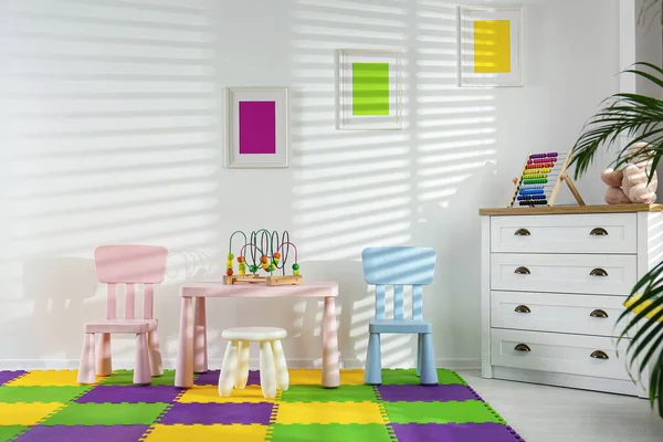 Стильный интерьер игровой комнаты с игрушками и современной мебелью — стоковое фото