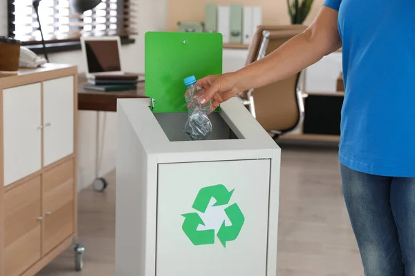 Vrouw gooit plastic fles in de prullenbak op kantoor, close-up — Stockfoto