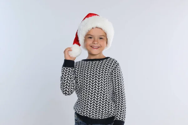 Criança feliz em chapéu de Papai Noel em fundo cinza claro. Celebração de Natal — Fotografia de Stock