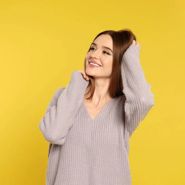 Hermosa mujer joven en suéter sobre fondo amarillo. Temporada de invierno —  Fotos de Stock