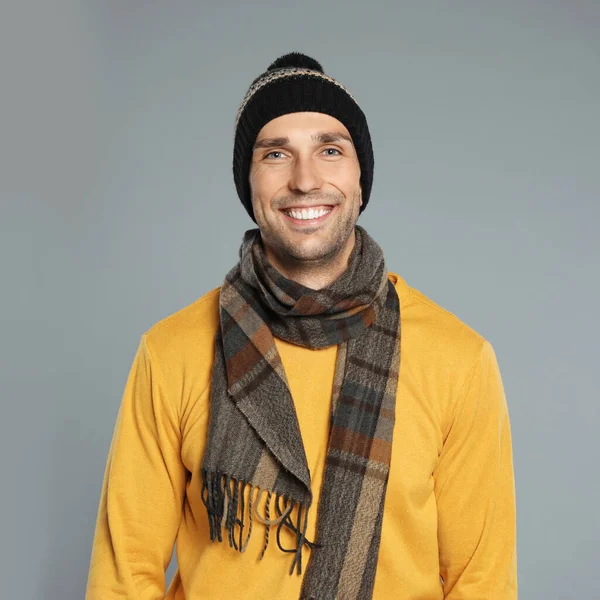 회색 배경에 따뜻 한 옷을 입은 행복 한 젊은이. 겨울 계절 — 스톡 사진
