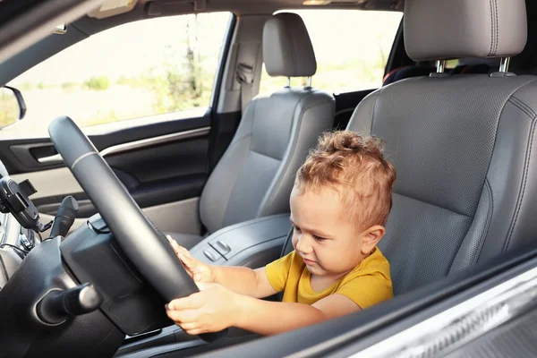 Kleiner Junge spielt mit Lenkrad im Auto Familienausflug — Stockfoto