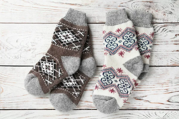 Warme gestrickte Socken auf weißem Holzgrund, flache Lage — Stockfoto