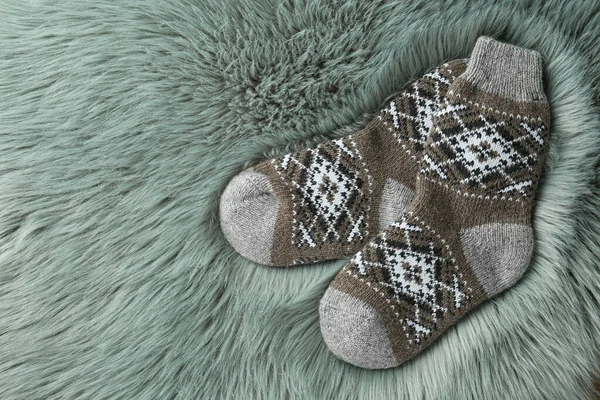 Pletené ponožky na šedé umělé kožešině, ploché. Mezera pro text — Stock fotografie