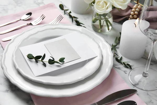 Елегантна святкова обстановка столу з порожньою карткою на білому мармуровому фоні — стокове фото