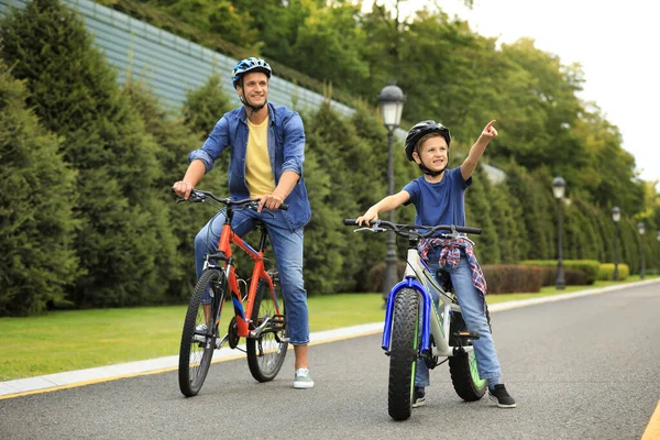 Папа и сын катаются на современных велосипедах на открытом воздухе — стоковое фото