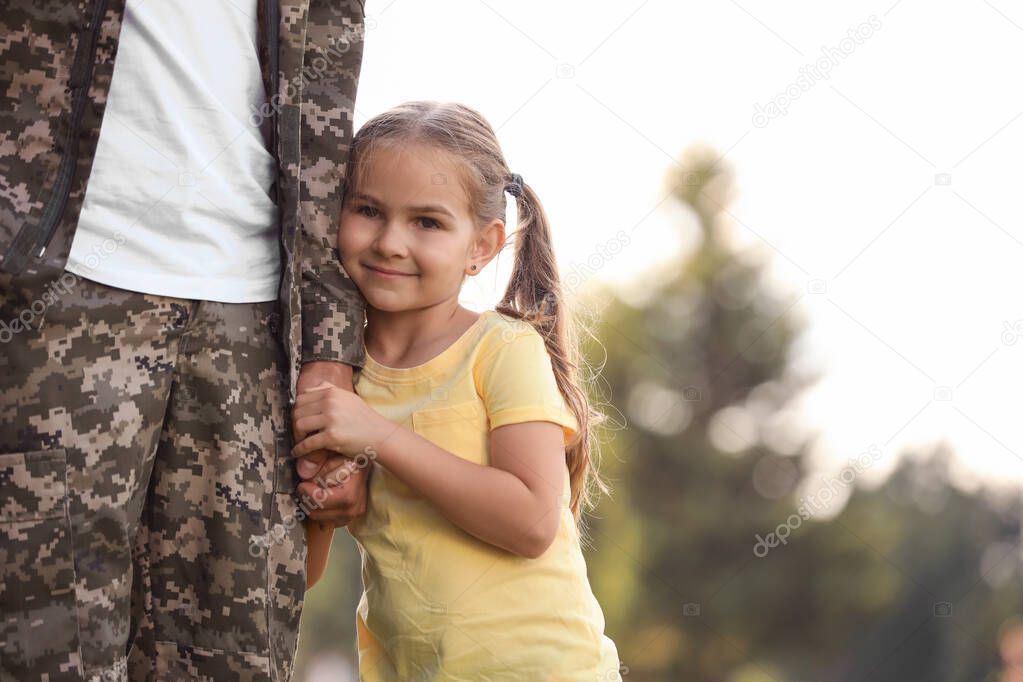 Little girl with her father in military uniform at sunny park