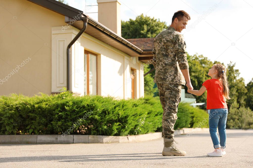 Father in military uniform with his little daughter outdoors