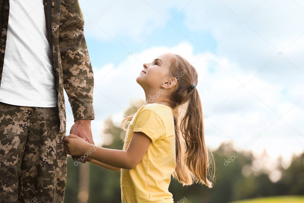 Little girl with her father in military uniform at sunny park