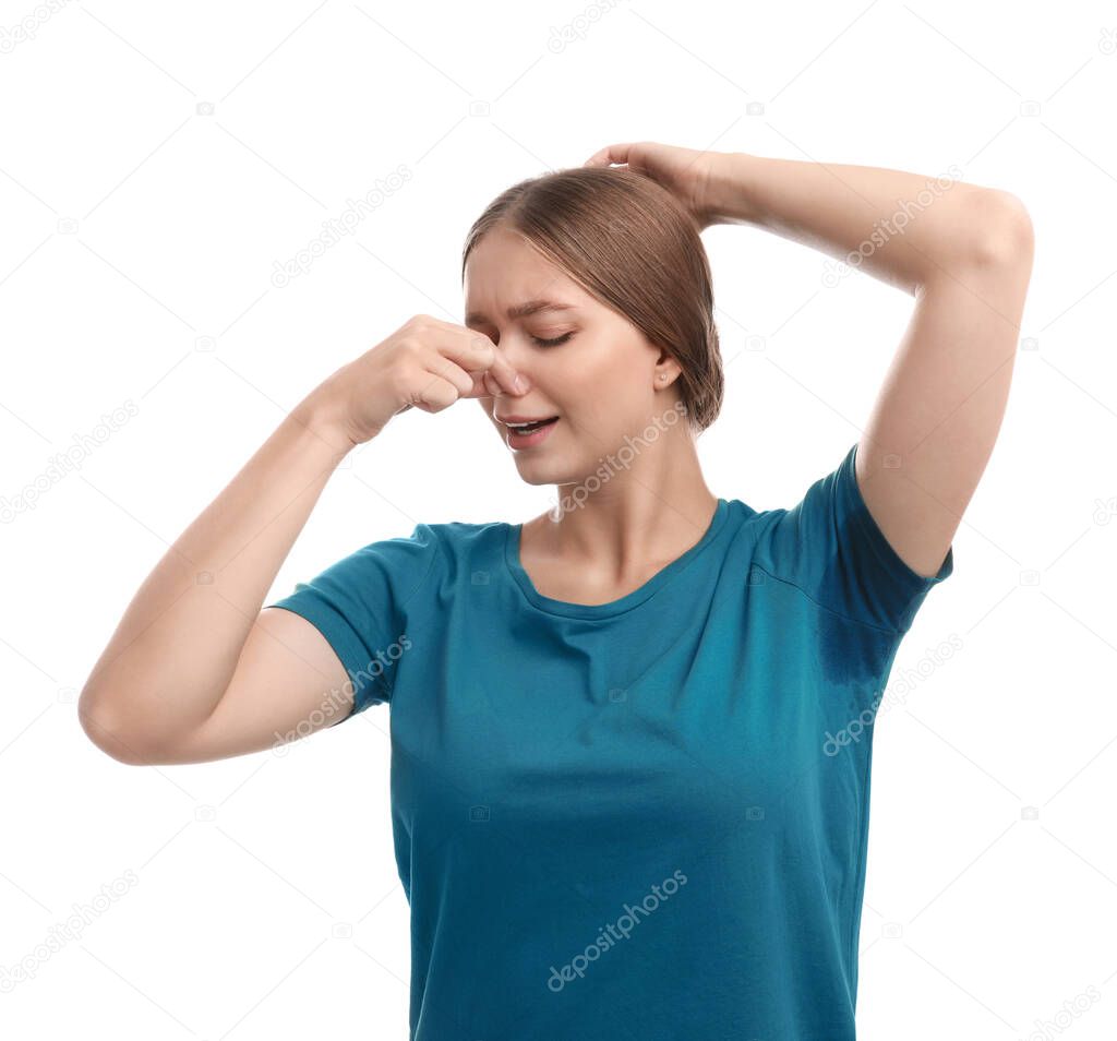 Young woman with sweat stain on her clothes against white background. Using deodorant