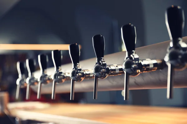 Row of shiny beer taps in pub — Stock Photo, Image