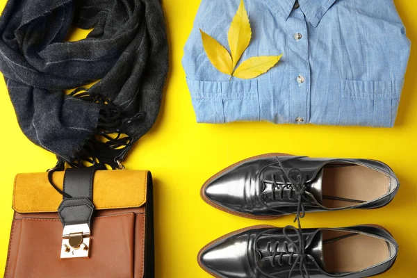 Flat lay composizione con vestiti caldi e foglie autunnali su sfondo giallo — Foto Stock