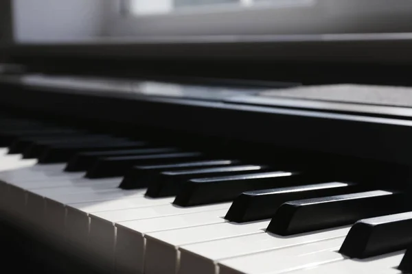 Piano moderno con teclas en blanco y negro en interiores, primer plano — Foto de Stock