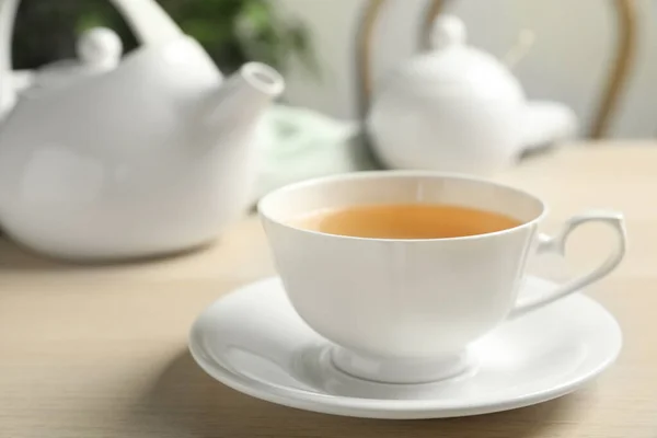 Filiżanka gorącej zielonej herbaty na drewnianym stole wewnątrz — Zdjęcie stockowe