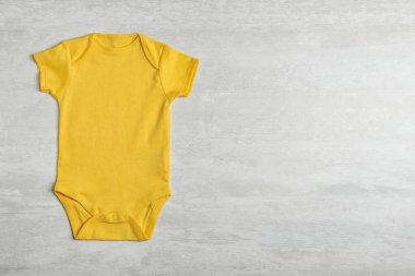 Ahşap arka plan üzerinde bebek bodysuit, üst görünümü. Metin için alan