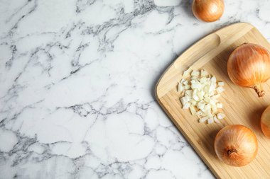 Tahta tahta, doğranmış ve mermer masada tam soğan, düz. Metin için boşluk