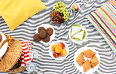 Piknik sepeti ve battaniyede farklı aperatifler.