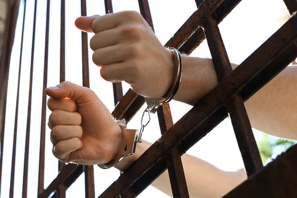 Hombre esposado en la cárcel al aire libre, vista de bajo ángulo. Derecho penal —  Fotos de Stock