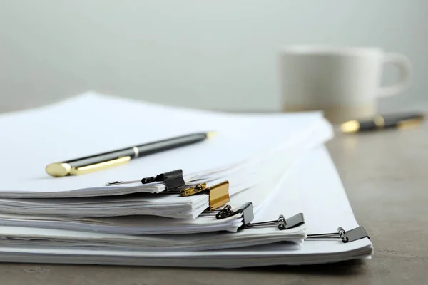 Pilha de documentos com grampos de aglutinante na mesa de luz, close-up — Fotografia de Stock