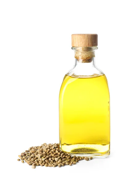Bottiglia con olio di canapa e semi su sfondo bianco — Foto Stock