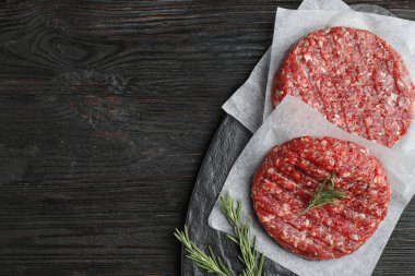 Hamburger için çiğ et. Siyah ahşap masa, üst manzara. Metin için boşluk