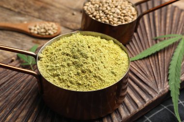Tahta üzerinde kenevir protein tozu ve tohumları olan bileşim, yakın plan.