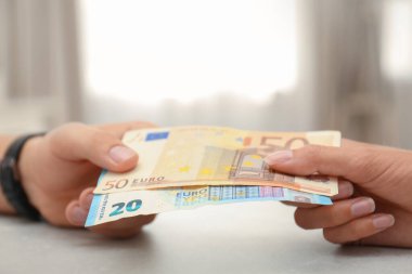 Avrupa banknotları olan insanlar kapalı masalarda, yakın plan.