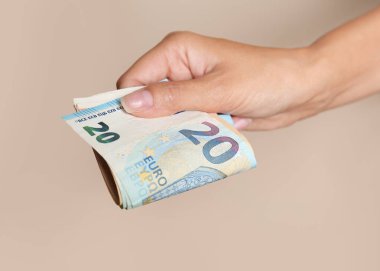Kahverengi arka planda Euro banknotları olan kadın, yakın plan.