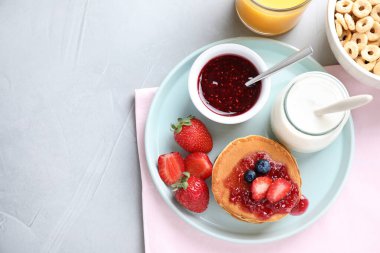 Açık gri masada leziz gözlemelerle bezenmiş düz kompozisyon, yazı için boşluk. Sağlıklı kahvaltı.