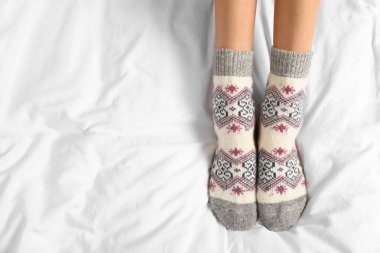 Beyaz kumaşa örülmüş çorap giyen bir kadın. Üstü açık, yazı için yeri olan bir kadın. Kalın kıyafetler.