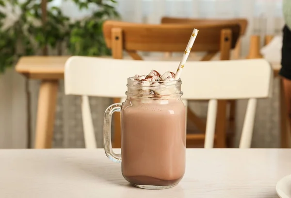 Läcker kakaodryck med marshmallows i masonburk på ljust bord — Stockfoto