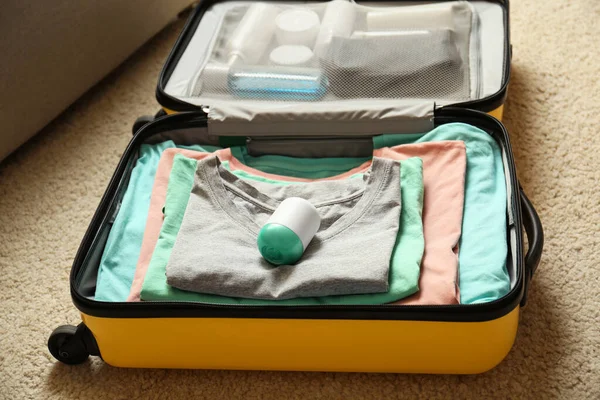 Дезодорант у упакованій валізі на підлозі в приміщенні — стокове фото