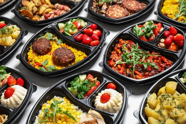 Lunchboxen met verschillende maaltijden op witte tafel. Gezonde voedselverstrekking — Stockfoto