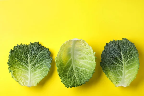 Foglie di verza fresche su fondo giallo, posa piatta — Foto Stock