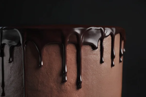 Freshly made delicious chocolate cake against black background, closeup — Stock Photo, Image