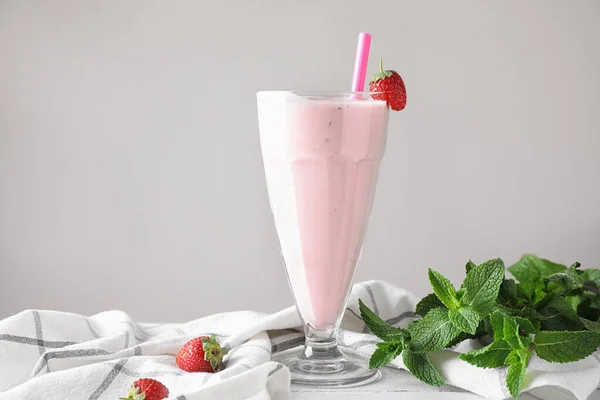 Sabroso batido de fresa en vaso sobre mesa —  Fotos de Stock