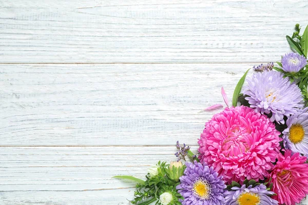 Płaska kompozycja świeckich z pięknymi kwiatami aster na białym drewnianym stole. Miejsce na tekst — Zdjęcie stockowe