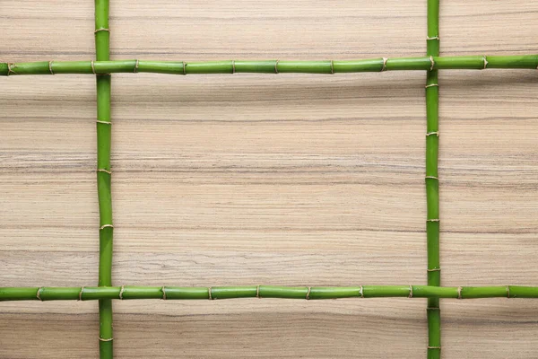 Frame made of green bamboo stems on wooden background. Space for text — Stock Photo, Image
