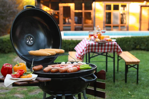 Barbecue grill with sausages and vegetables outdoors — Stock Photo, Image