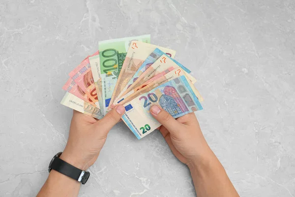 Человек с банкнотами евро за столом, вид сверху — стоковое фото