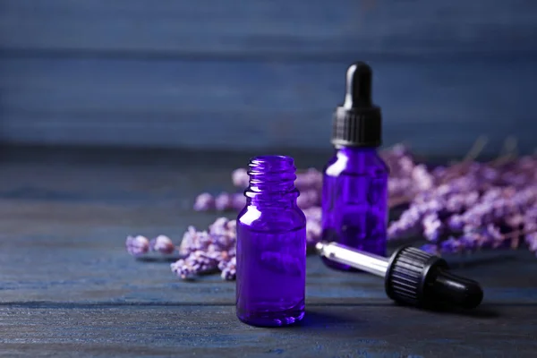 Flaschen ätherisches Lavendelöl auf blauem Holzgrund — Stockfoto