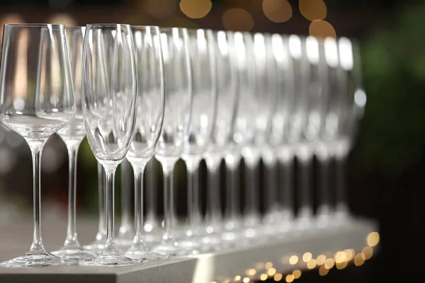 Set lege glazen op grijze tafel tegen wazige achtergrond — Stockfoto