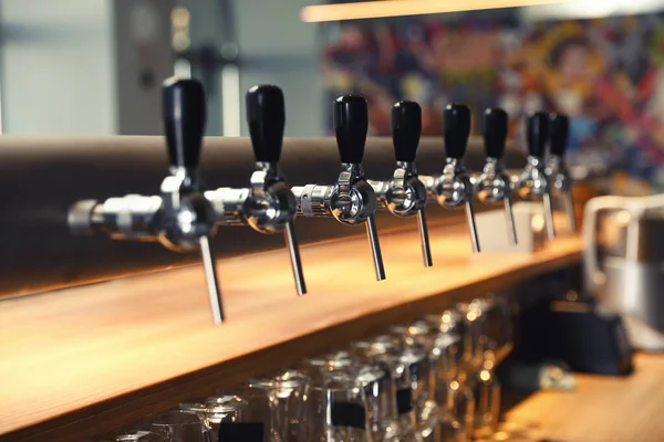 Row of shiny beer taps in pub — Stock Photo, Image